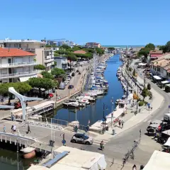 Un canale navigabile a Cervia, dove si trova un vivace porto turistico con barche a vela ormeggiate e case colorate lungo le rive.