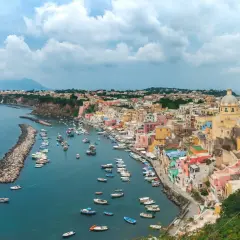 Un pittoresco borgo colorato sul mare vicino Napoli, con barche ormeggiate in un porto tranquillo e una vista mozzafiato.