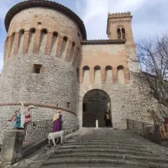 Presepe vivente a Corciano: cosa vedere. La rocca medievale fa da sfondo a figure sacre e un agnello.