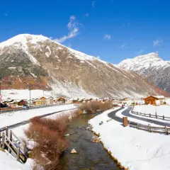 Livigno a novembre: un paesaggio innevato con montagne maestose, un fiume serpeggiante e un villaggio alpino. Ideale per scoprire cosa fare a Livigno in questo periodo.
