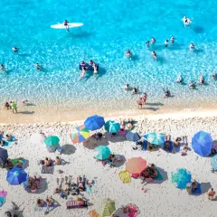 Viste aeree delle spiagge di Tropea, con bagnanti che si godono il sole e il mare cristallino.