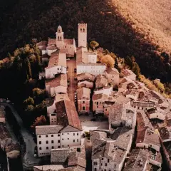 Borghi vicino Nocera Umbra, un gioiello medievale arroccato su una collina, con torri e tetti in terracotta immersi nel verde autunnale.