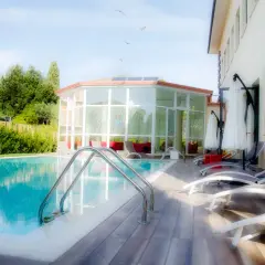 Statua classica vicino alla piscina, con un edificio moderno e un giardino lussureggiante. Un'oasi di relax a Gambassi Terme.