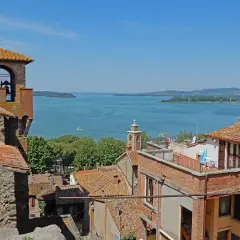 Vista panoramica di Passignano sul Trasimeno: campanile, tetti rossi e il lago azzurro. Ecco cosa vedere!