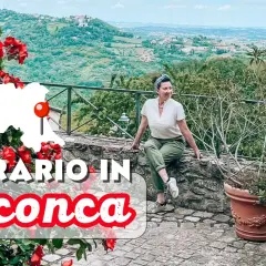 Un itinerario in Valconca, Rimini, tra colline verdi e rose rosse. Una donna sorride godendosi il panorama.