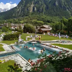 Un resort con piscine termali e persone rilassate, circondato da montagne verdi. Un'oasi di pace, quasi come le terme di Torino ma in montagna.