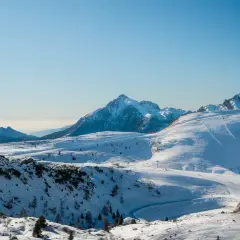 Un paesaggio innevato con piste da sci e una baita, una montagna vicino Milano a 1 ora di distanza.