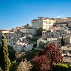 Un borgo medievale arroccato su una collina, con case in pietra e un imponente palazzo. Questo è dove si trova Todi, un gioiello umbro.