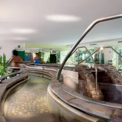 Piscine interne con acqua calda e pietre sul fondo, un percorso rilassante nei bagni di Rabbi.