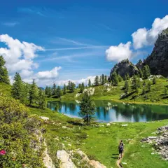 Sentiero panoramico nella Valle Maira, cosa vedere: un lago alpino specchiato, rocce imponenti e sentieri verdi.