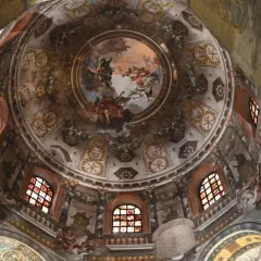 Cupola affrescata con scene celesti e simboli cristiani, un capolavoro da non perdere per chi visita Ravenna cosa vedere in un giorno.