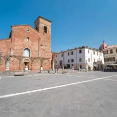 Piazza principale di Sarsina, dove si trova la Basilica di San Vincenzo Martire, con edifici storici e cielo azzurro.