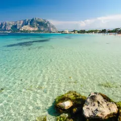 Splendido mare cristallino vicino Palermo, con la costa e il Monte Pellegrino sullo sfondo.