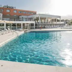 Piscina con lettini e ombrelloni in un resort a Venturina Terme. Un'oasi di relax dove godersi il sole e l'acqua cristallina, un'esperienza quasi venturina terme kostenlos.