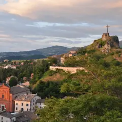 Panoramica di Pennabilli, Rimini, con la chiesa e la rocca con la croce che domina il paesaggio collinare al tramonto.