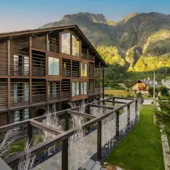 Edificio in legno con balconi e vista su una montagna vicino Milano in estate.