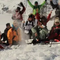 Un gruppo di amici si diverte con le ciaspolate in Val d'Aosta, tra risate e lanci di neve.