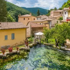 Borgo pittoresco con case gialle e un ruscello cristallino. Un'ottima meta per scoprire cosa vedere vicino Assisi.