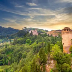 Brisighella, un borgo medievale in Emilia-Romagna, con la sua Rocca Manfrediana e la chiesa sulla collina, immerso nel verde.