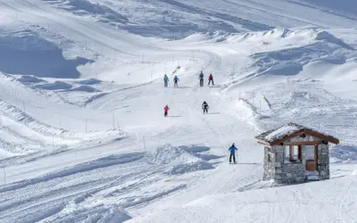 Sciare in un paesaggio innevato, perfetto per una settimana bianca in Piemonte. Piccola baita di pietra sulla pista.