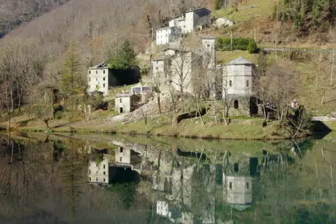Borghi antichi e riflessi sull'acqua: ecco cosa vedere in Garfagnana. Un paesaggio incantevole con case in pietra e torri medievali.