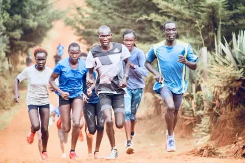 Atleti corrono su un sentiero sterrato. Un gruppo di corridori, uomini e donne, affronta una gara. Per chi vuole iniziare il trail running, questo è uno spunto.