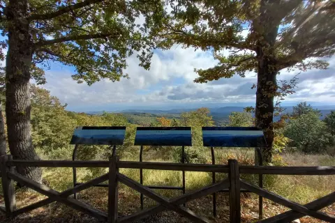 Pannello informativo con panorama mozzafiato. Un invito a scoprire cosa vedere in questo paesaggio collinare.