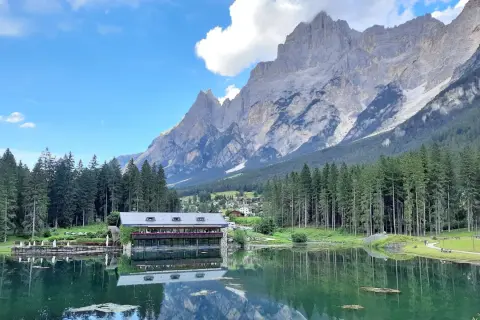 Lago alpino con rifugio e montagne maestose, ideale per passeggiate facili in Cadore.