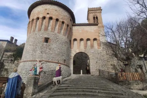 Presepe vivente a Corciano: cosa vedere. La rocca medievale fa da sfondo a figure sacre e un agnello.