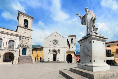 Norcia, famosa per San Benedetto, patrono d'Europa, con la sua basilica e il monumento in piazza.