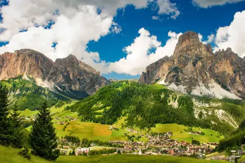 Un villaggio alpino incastonato tra imponenti vette rocciose e verdi pascoli. Una splendida località di montagna.