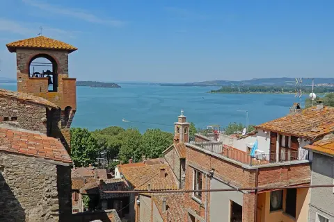 Vista panoramica di Passignano sul Trasimeno: campanile, tetti rossi e il lago azzurro. Ecco cosa vedere!