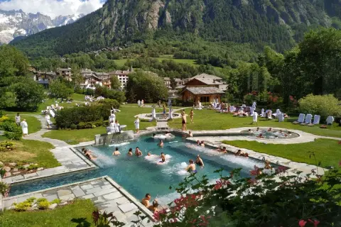 Un resort con piscine termali e persone rilassate, circondato da montagne verdi. Un'oasi di pace, quasi come le terme di Torino ma in montagna.