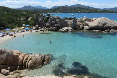 Spiagge di San Teodoro con acque cristalline, rocce granitiche e gente che si gode il sole e il mare.