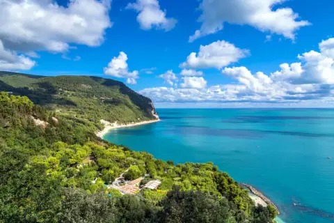 Vista mozzafiato del Monte Conero, dove il verde lussureggiante incontra il blu intenso del mare Adriatico.