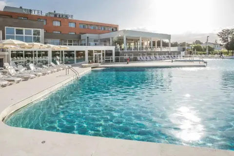 Piscina con lettini e ombrelloni in un resort a Venturina Terme. Un'oasi di relax dove godersi il sole e l'acqua cristallina, un'esperienza quasi venturina terme kostenlos.