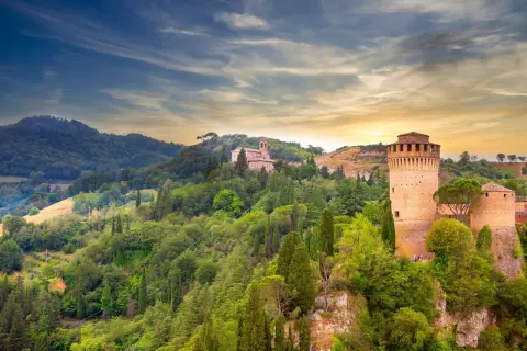 Brisighella, un borgo medievale in Emilia-Romagna, con la sua Rocca Manfrediana e la chiesa sulla collina, immerso nel verde.