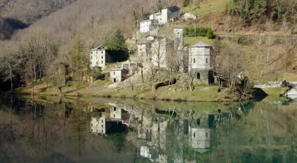 Borghi antichi e riflessi sull'acqua: ecco cosa vedere in Garfagnana. Un paesaggio incantevole con case in pietra e torri medievali.