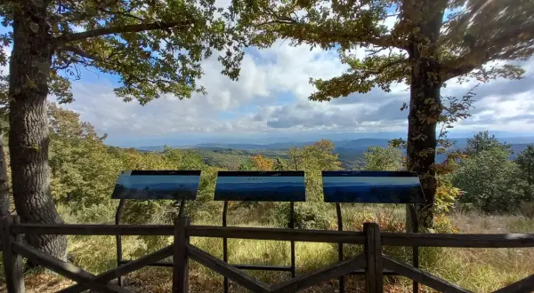 Pannello informativo con panorama mozzafiato. Un invito a scoprire cosa vedere in questo paesaggio collinare.