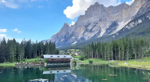 Lago alpino con rifugio e montagne maestose, ideale per passeggiate facili in Cadore.