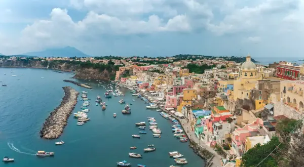 Un pittoresco borgo colorato sul mare vicino Napoli, con barche ormeggiate in un porto tranquillo e una vista mozzafiato.