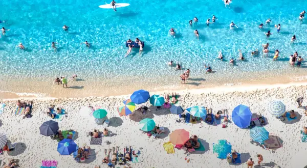 Viste aeree delle spiagge di Tropea, con bagnanti che si godono il sole e il mare cristallino.