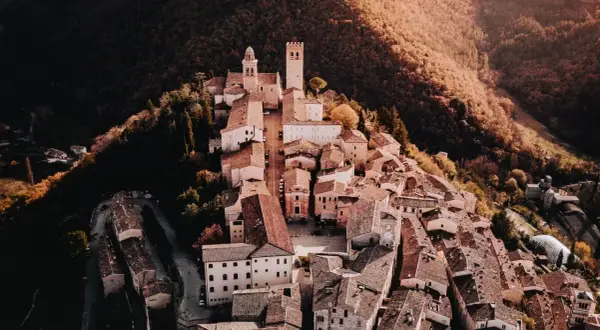 Borghi vicino Nocera Umbra, un gioiello medievale arroccato su una collina, con torri e tetti in terracotta immersi nel verde autunnale.