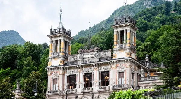 Edificio storico con torri e decorazioni elaborate, immerso nel verde delle montagne. Un luogo incantevole per una **spa San Pellegrino**.