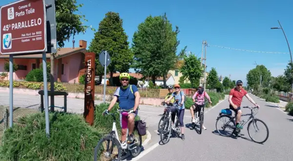 Ciclisti lungo il percorso fiume Po, vicino al cartello del 45° parallelo a Porto Tolle.