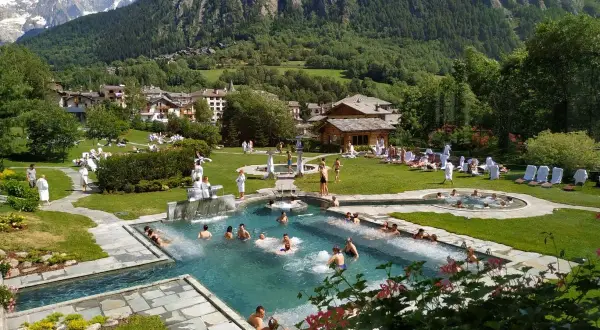 Un resort con piscine termali e persone rilassate, circondato da montagne verdi. Un'oasi di pace, quasi come le terme di Torino ma in montagna.