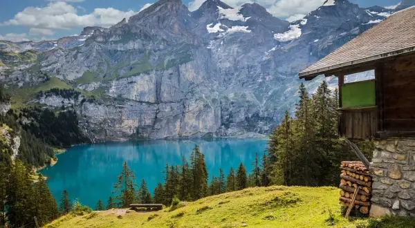 Incantevole montagna in Italia con lago turchese e baita in legno.