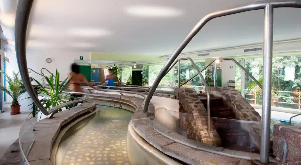 Piscine interne con acqua calda e pietre sul fondo, un percorso rilassante nei bagni di Rabbi.