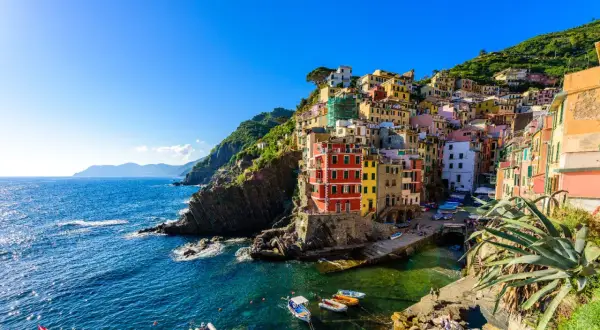 Riomaggiore, uno dei i 10 borghi più belli della Liguria, con le sue case colorate a picco sul mare blu.