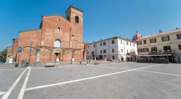 Piazza principale di Sarsina, dove si trova la Basilica di San Vincenzo Martire, con edifici storici e cielo azzurro.